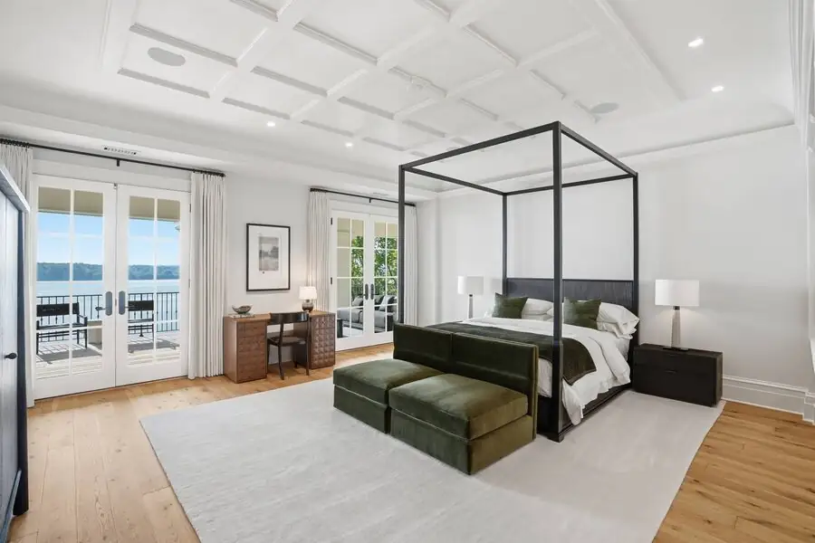 Primary bedroom &mdash; canopy bed, river through doors